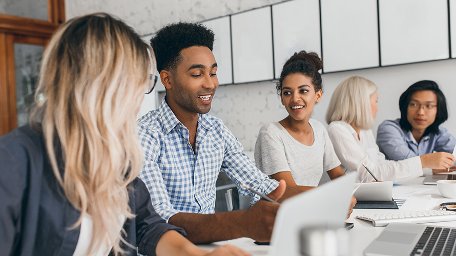 A Man Sitting With A Bunch Of Women By A Woirk Table